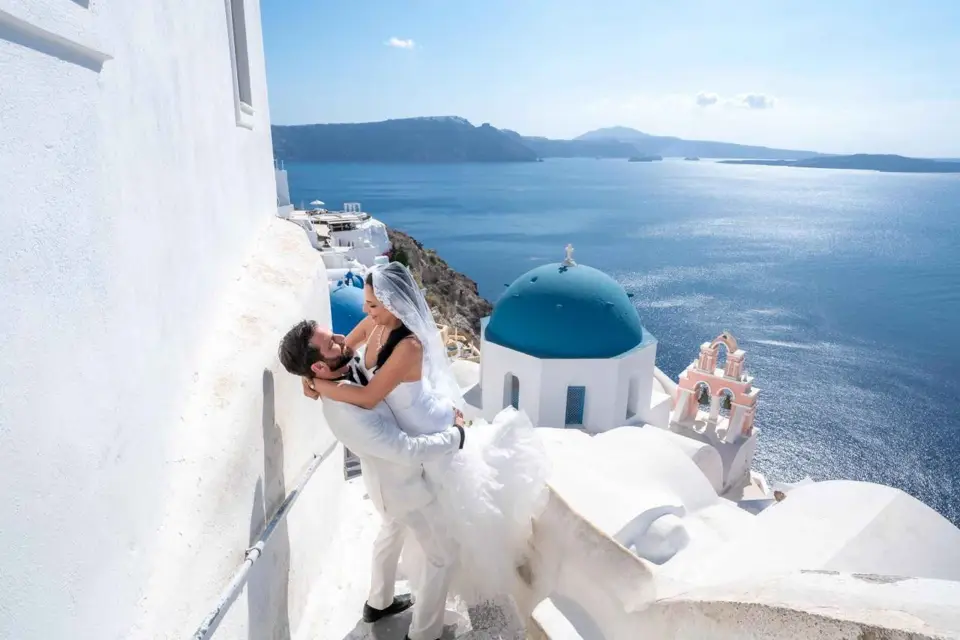 Sesión de fotos en Santorini con cúpulas azules y vistas a la Caldera